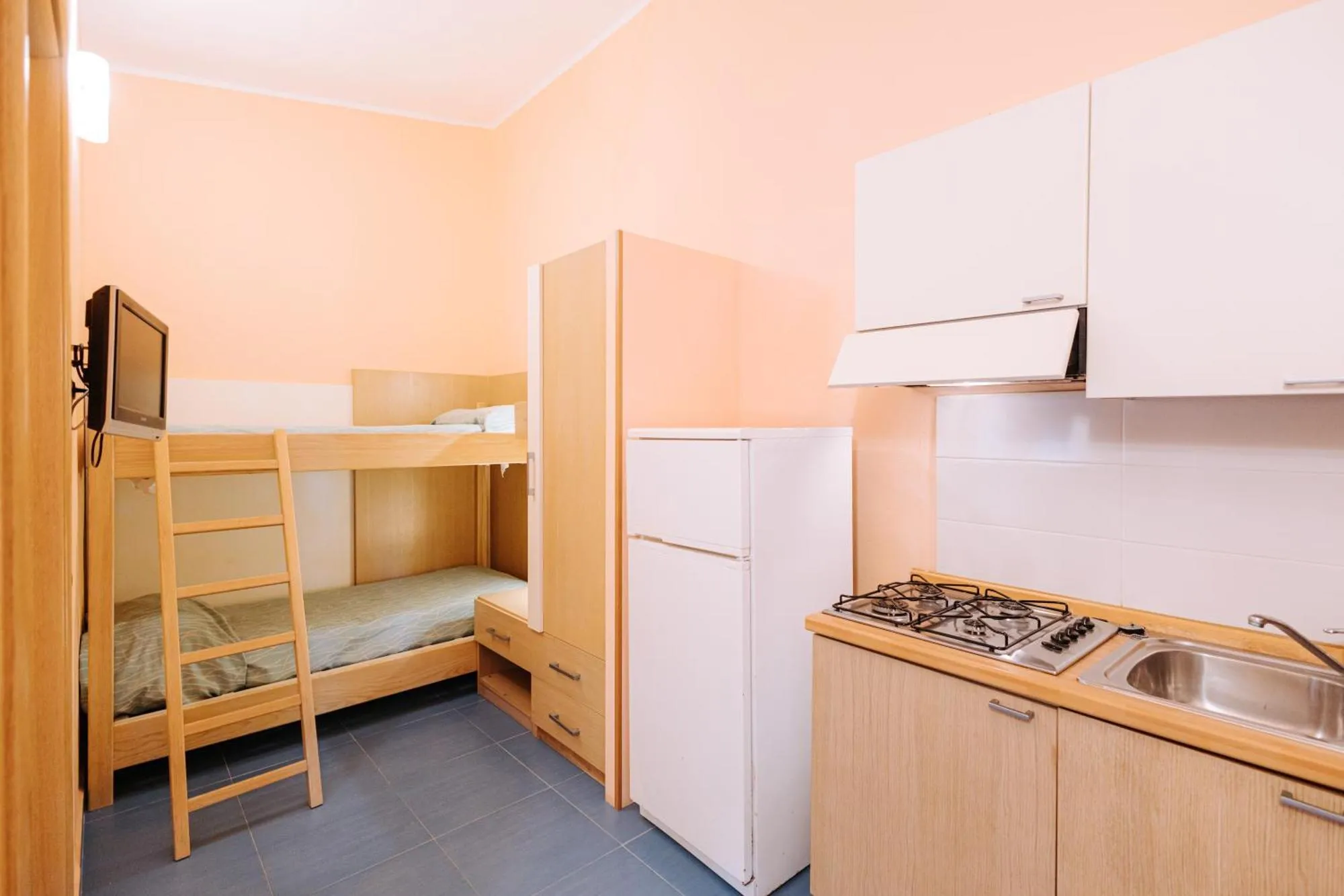 Monolocale con letto a castello, angolo cottura attrezzato e frigorifero